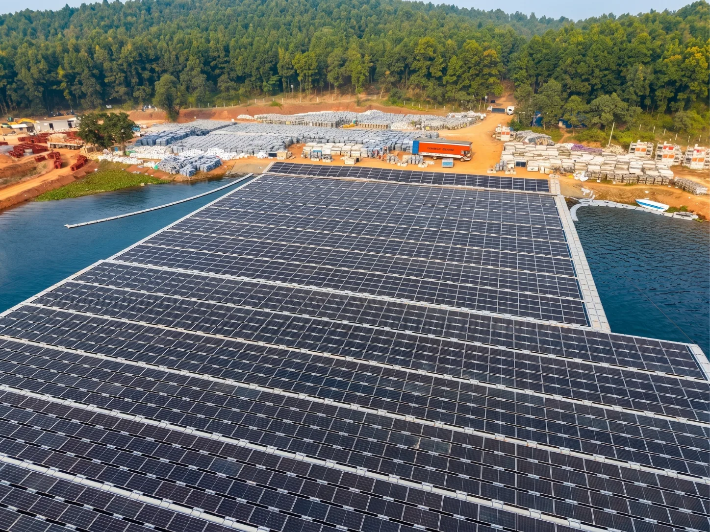 Grid evacuation infrastructure carrying power from a floating solar array on a remote reservoir toward the shore and utility network