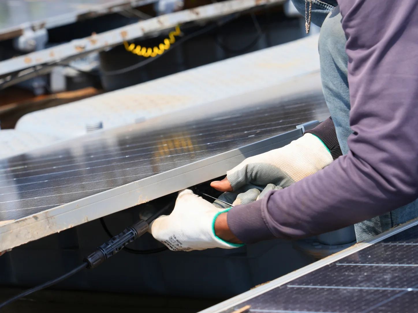 Technician connecting cabling on a floating solar array, illustrating the hands-on engineering scrutiny behind technical due diligence